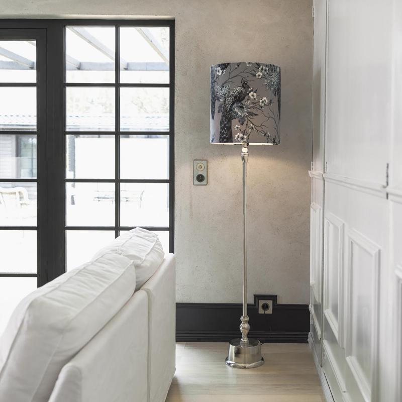 hög lampfot i metall stående i ett hörn i ett rum