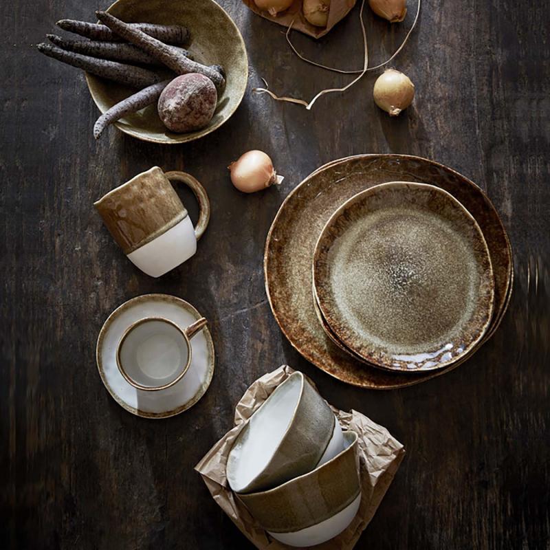 tallrikar jordfärgad keramik på ett mörkt bord
