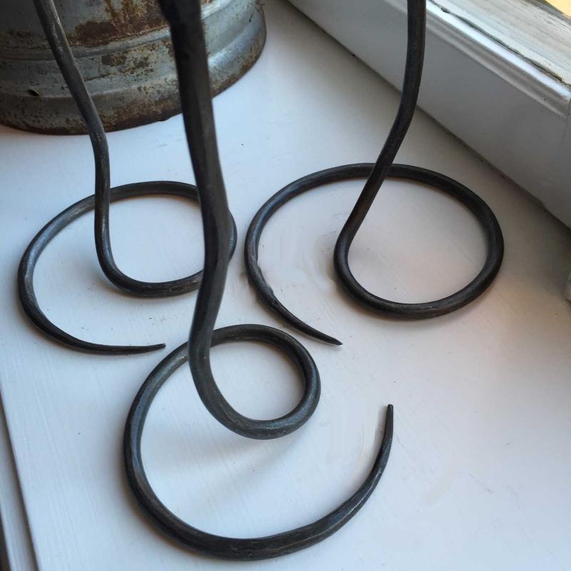 närbild på fötter till svarta ljusstakar i smide