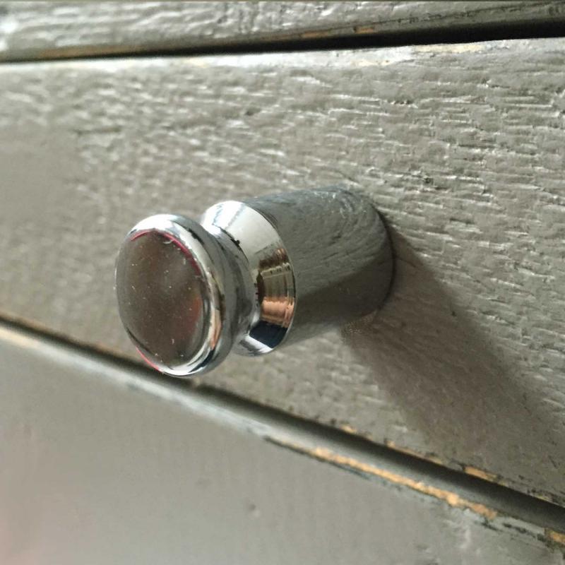 handtag knopp i metall monterat på låda