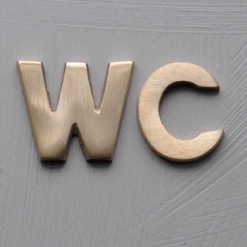 WC - bokstäver i borstad mässing