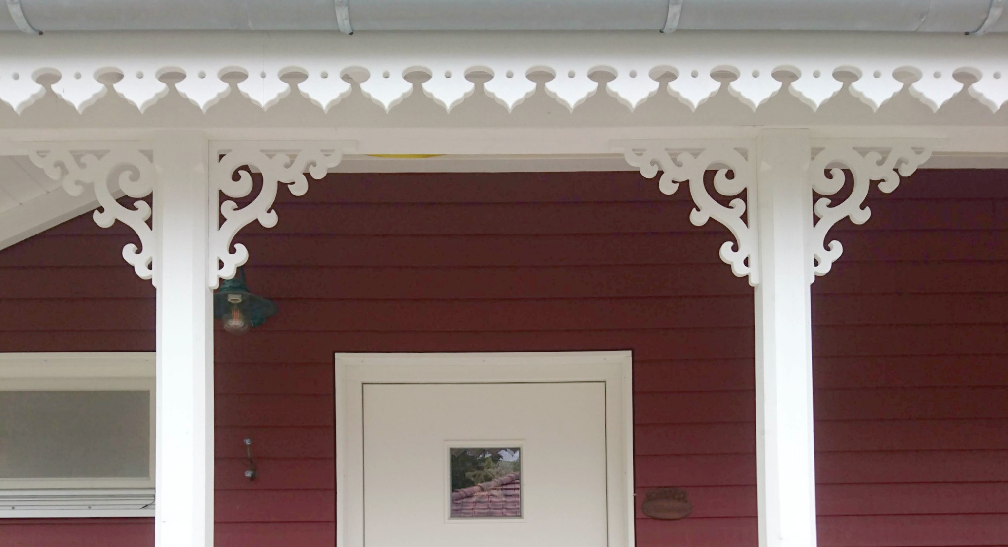 Eckkonsole 001 - Eine rote Veranda, dekoriert mit dem Ziergiebel von Gaveldekor aus Schweden.