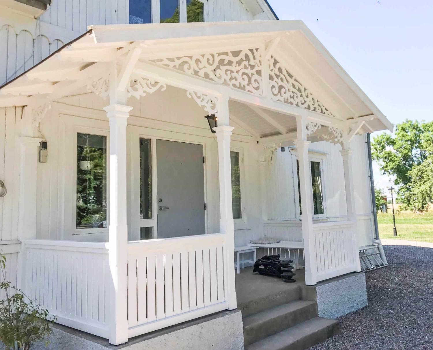 En klassisk vit farstukvist och farstubro med träkonsol 020 och fyllnadsdekor 030 från Gaveldekor. - En veranda med inspiration från sekelskifte och 1800-tal - Snickarglädje och nockdekor - tillverkad i Sverige - unik design