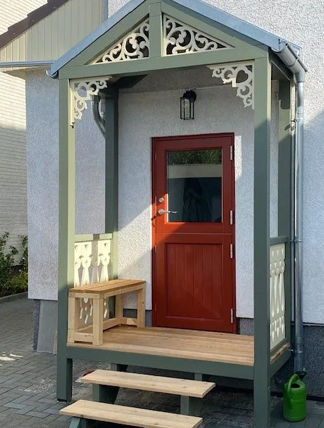 En klassisk ljusgrön veranda med träkonsoler och nockdekor från Gaveldekor - En veranda med inspiration från sekelskifte och 1800-tal - Husdekoration och dekoration för taknock - tillverkad i Sverige - unik design