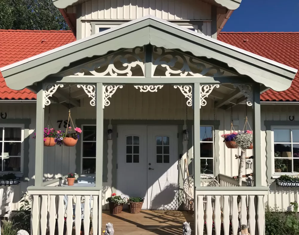 En klassisk ljusgrön veranda med träkonsol 020 från Gaveldekor. - En veranda med inspiration från sekelskifte och 1800-tal - Husdekoration och dekoration för taknock - tillverkad i Sverige - unik design