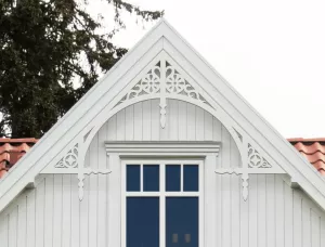 Gable pediment 001 - A white house with decorative wooden victorian millwork as house decoration for roof and gable end.