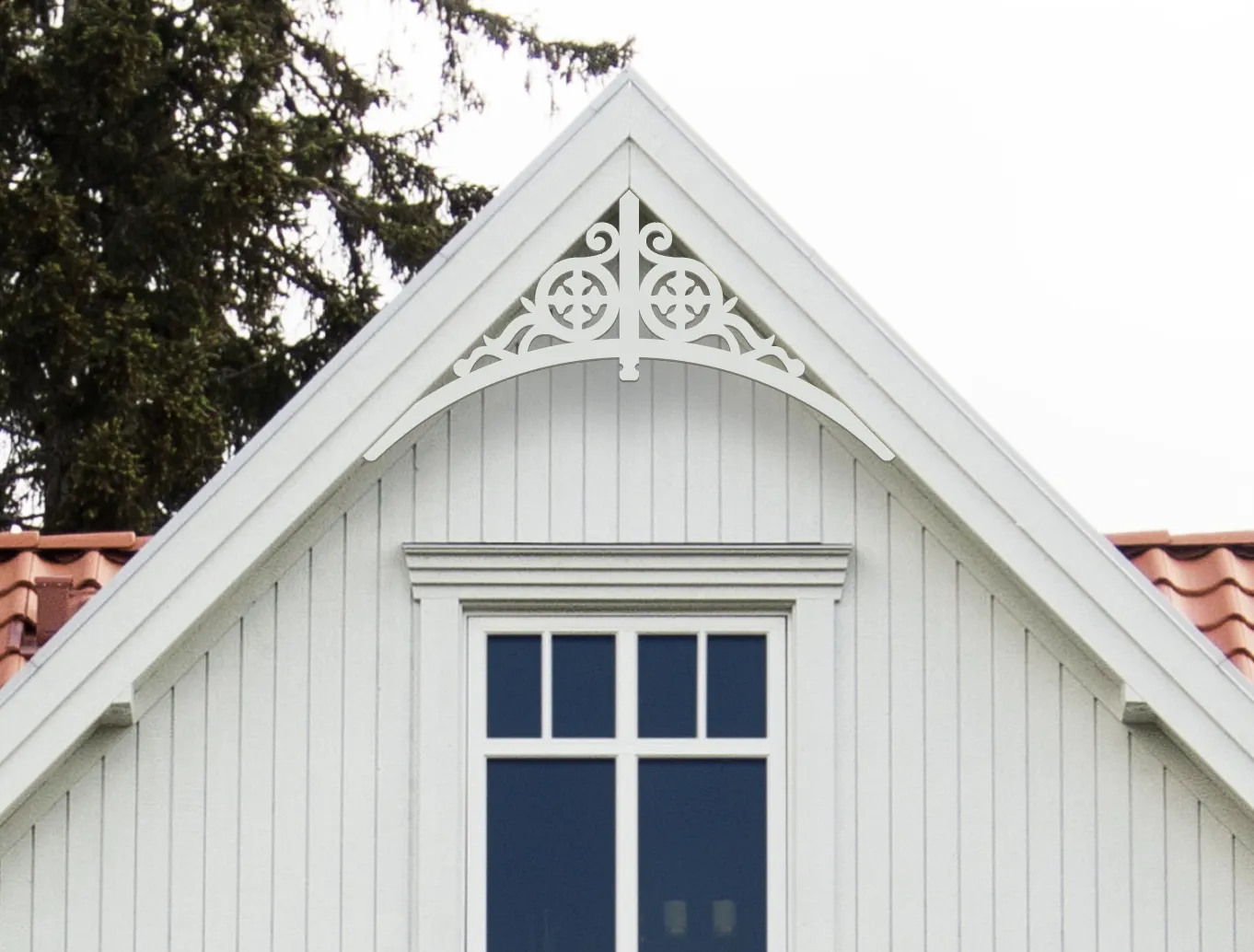Gable pediment 004 - A white house with decorative wooden victorian millwork as house decoration for roof and gable end.