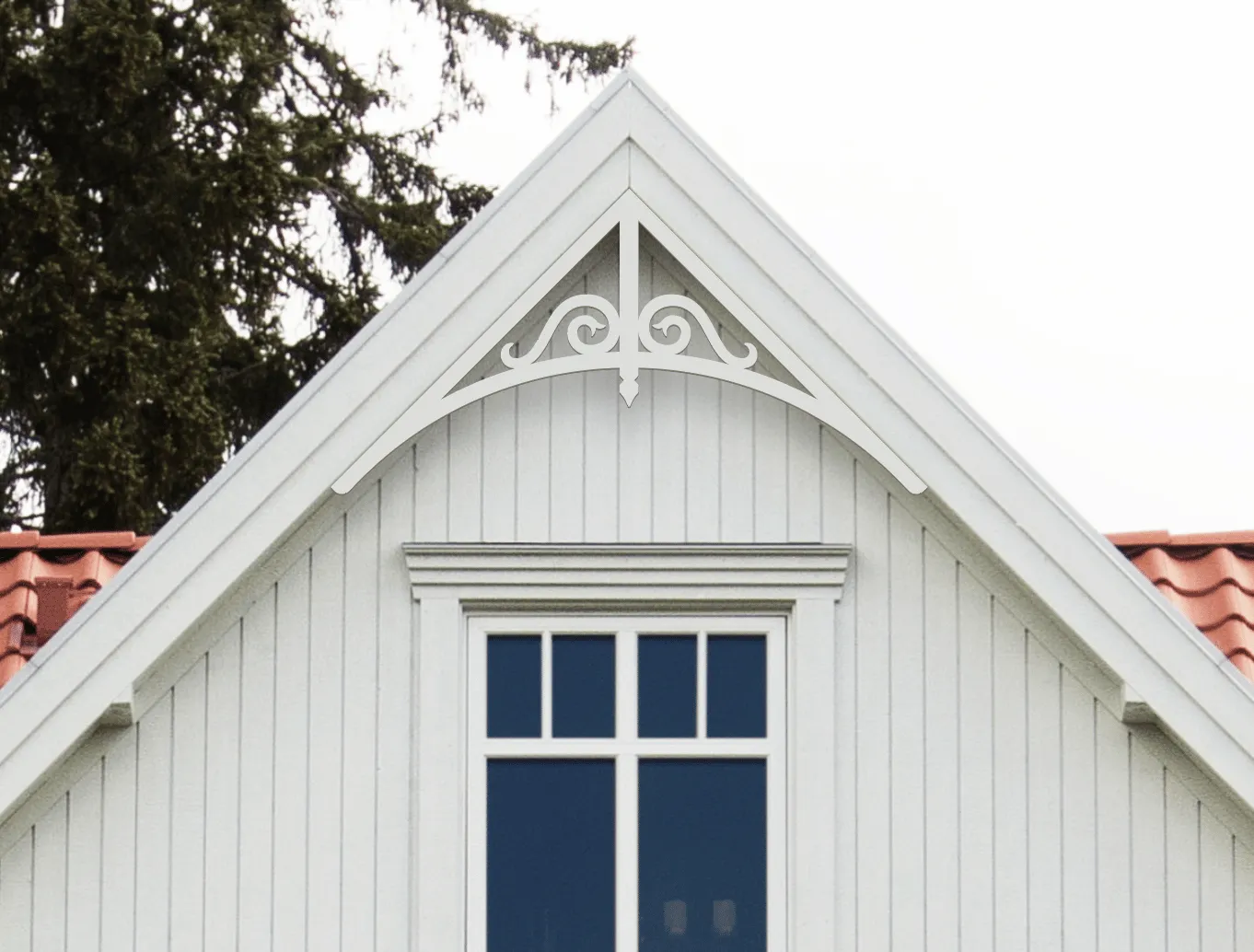 Gable pediment 005 - A white house with decorative wooden victorian millwork as house decoration for roof and gable end.
