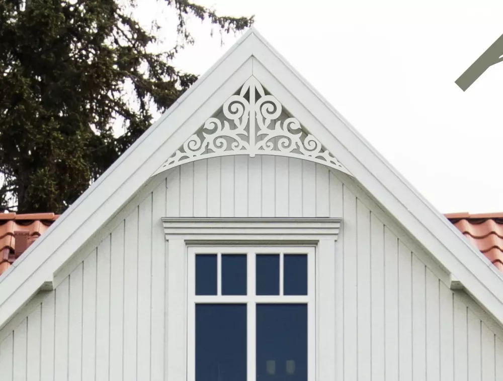 Gavelornament nr 011 med snickarglädje för dekoration av tak och taknock. Här visar vi gavelornamentet där övre ramen i ornamentet skjuts upp bakom vindskivan, ett annat sätt att montera dekoren på.