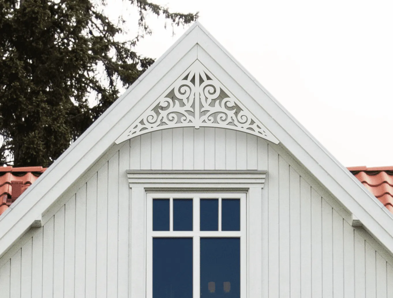 Gable pediment 011 - A white house with decorative wooden victorian millwork as house decoration for roof and gable end.