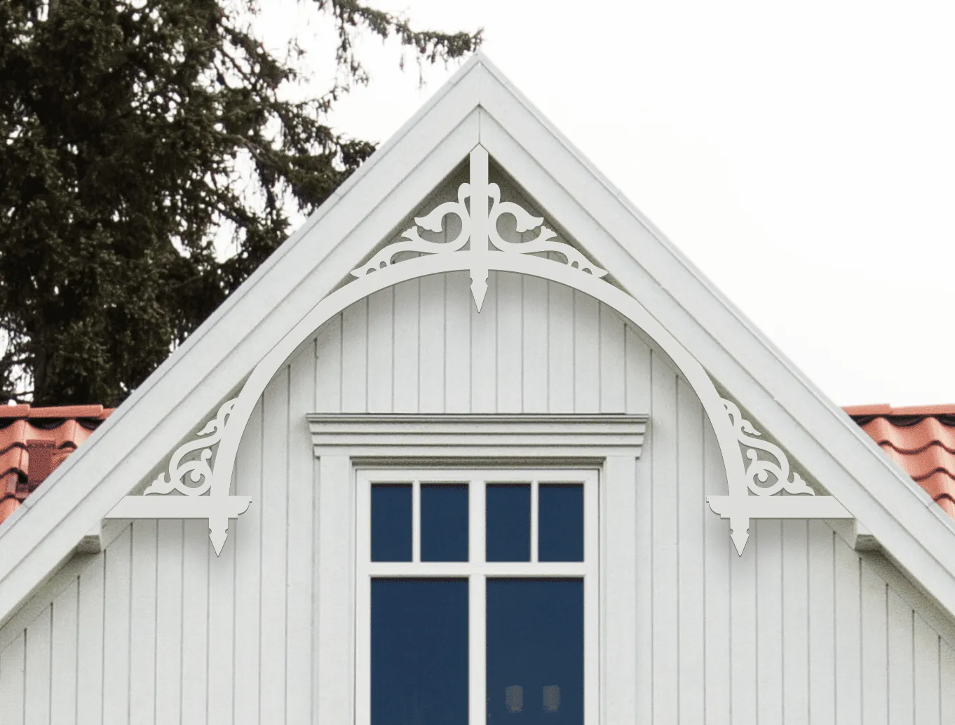 Gable pediment 050 - A white house with decorative wooden victorian millwork as house decoration for roof and gable end. The top frame is mounted behind the eaves.