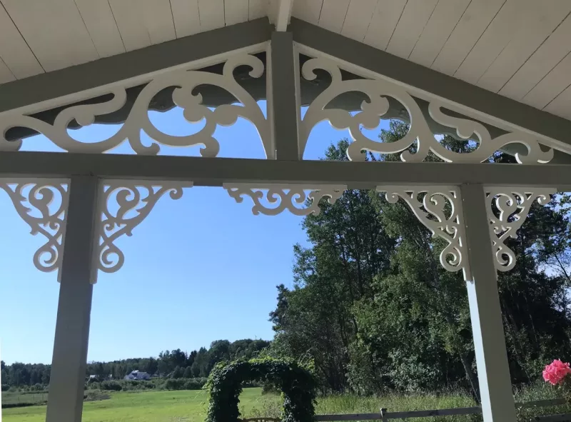 Inspirationsbild med en veranda och farstukvist med dekoration och snickarglädje, samt snygga träkonsoler för utomhusbruk.