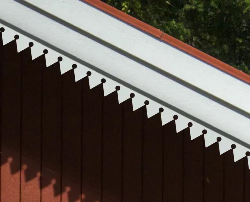 Rött hus med vindskivedekor nr 019 - Trälister med mönster av kringlor som snickarglädje och husdekor för vindskiva, tak ock taknock.