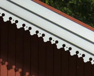 Ein rotes Haus, dekoriert mit dem Pfettenbrett 005. Hergestellt aus Holz in Schweden.