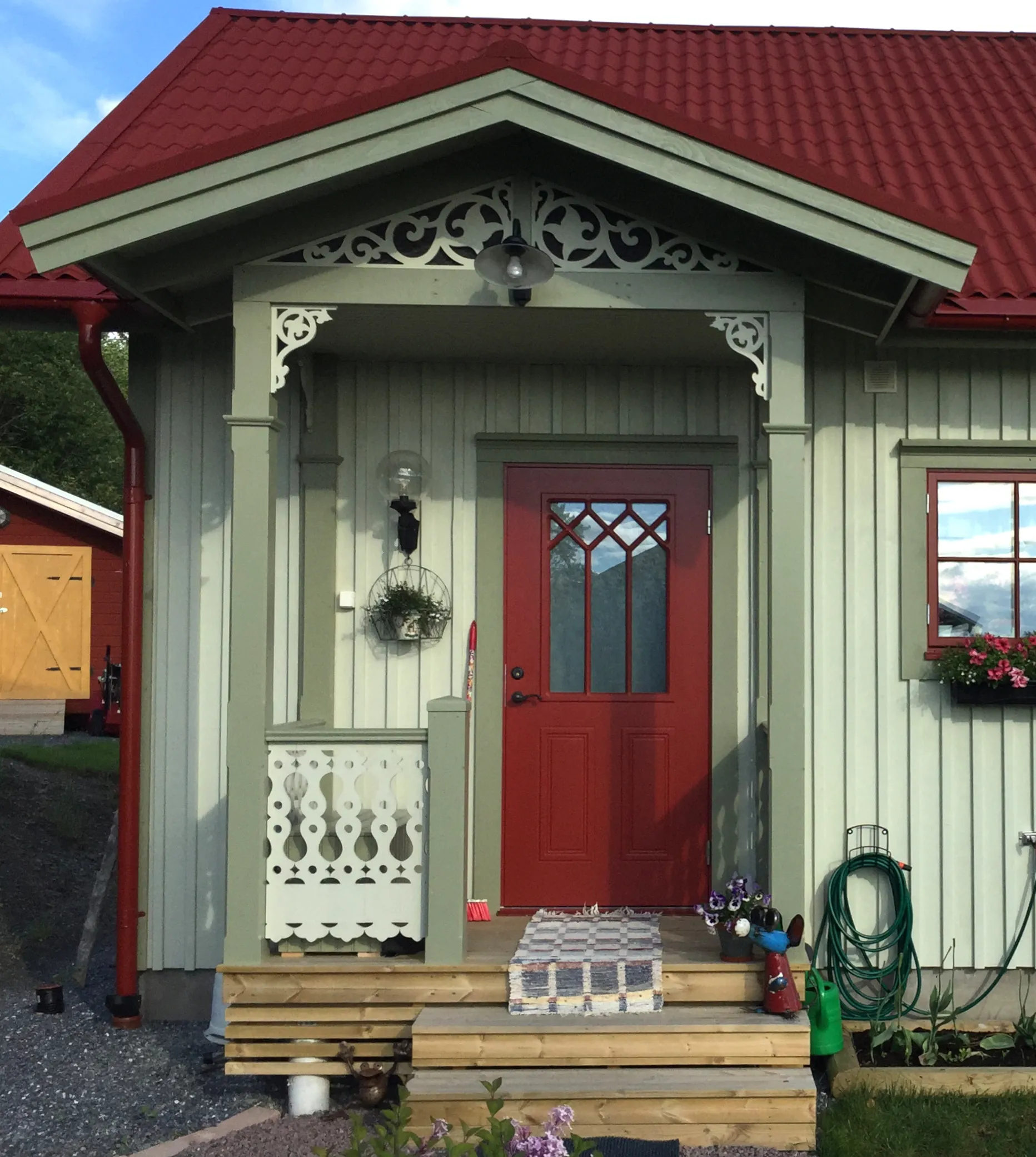 En klassisk ljusgrön veranda med träkonsoler och nockdekor från Gaveldekor - En veranda med inspiration från sekelskifte och 1800-tal - Husdekoration och dekoration för taknock - tillverkad i Sverige - unik design