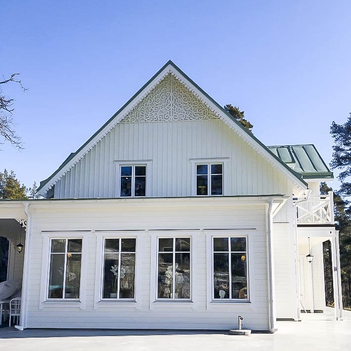 Ein weißes Haus mit Zierornamente, Giebelverzierung 030 für Dach und Fassade - Giebel und Winkel dekorieren mit Pfettenbrett. Hergestellt aus Holz in Schweden.