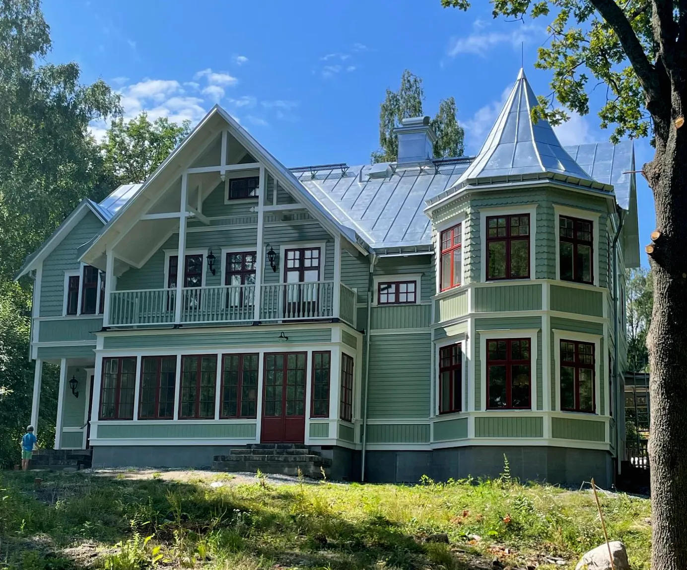 Ein grünes Haus mit Veranda und viel Hausdekoration - Holzkonsolen - Ein wunderschönes Jahrhundertwende-Haus mit Inspiration von roten Fenstern aus der Jahrhundertwende und dem Stil des 19. Jahrhunderts - Gaveldekor.
