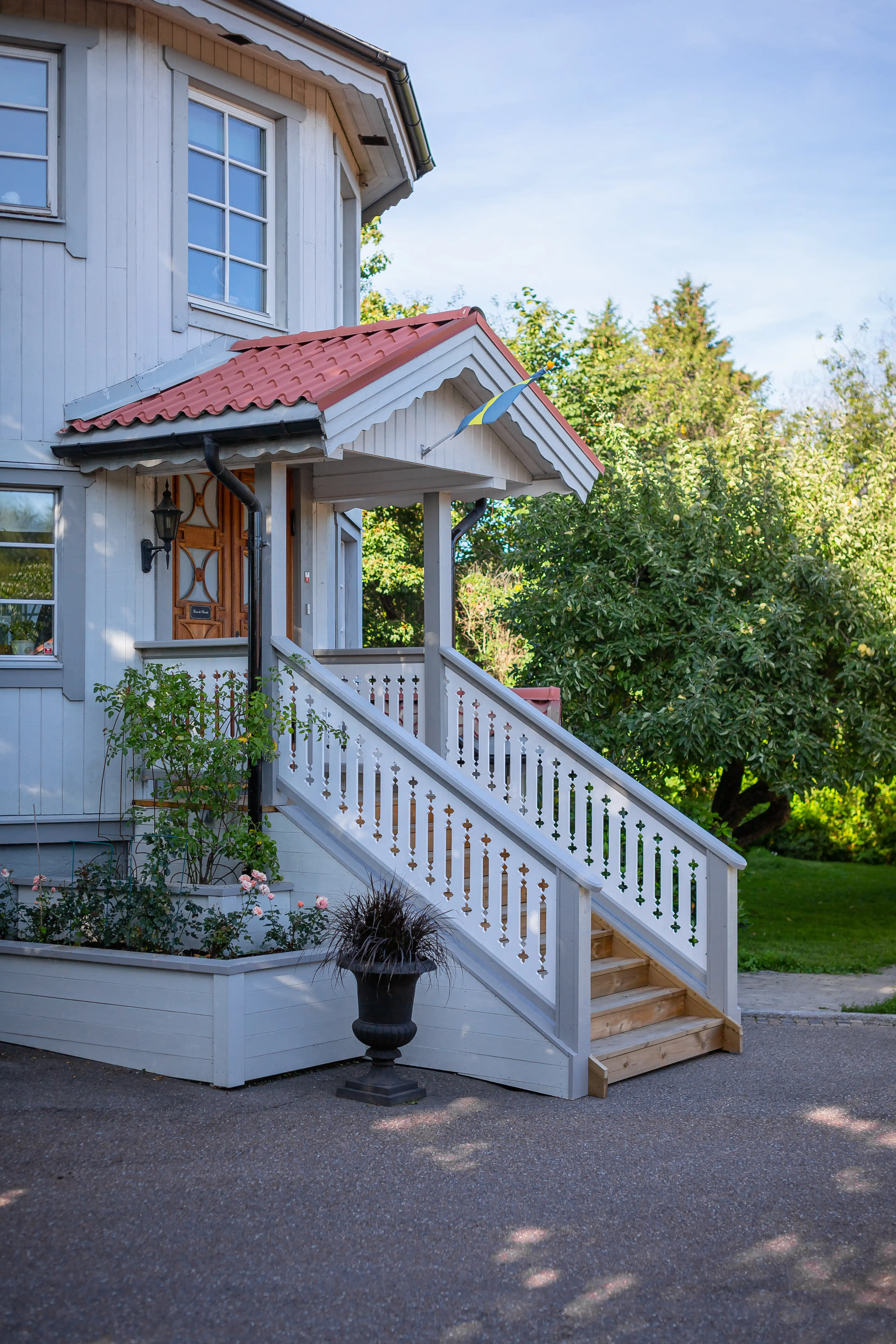 An elegant staircase leading to a porch with white-painted railings in turn-of-the-century and 19th-century style - vintage with a touch of rustic charm