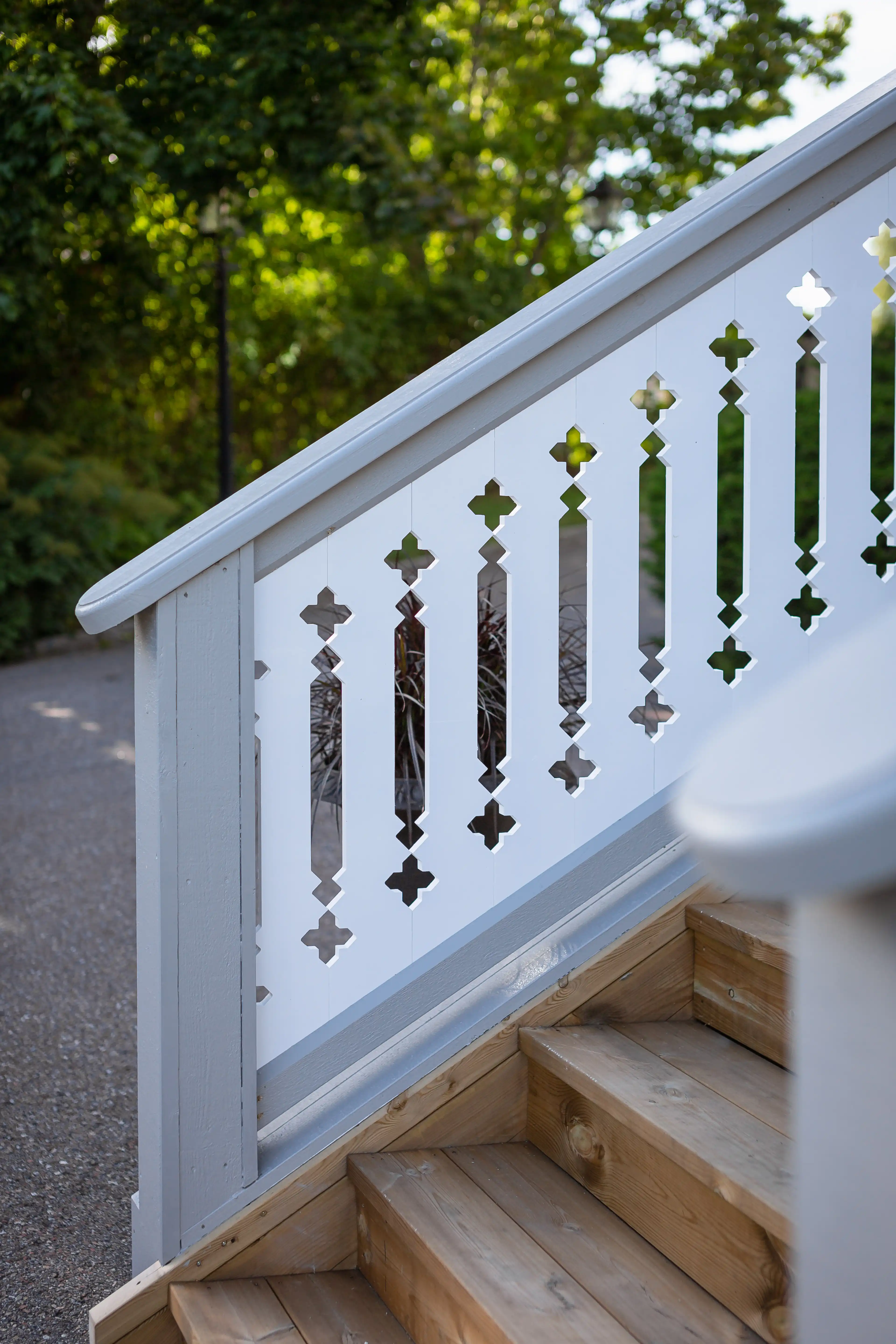 An elegant staircase leading to a porch with white-painted railings in turn-of-the-century and 19th-century style - vintage with a touch of rustic charm