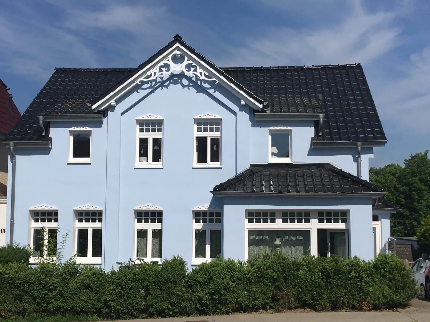 Ein blau Haus, dekoriert mit dem Giebeschmuck. Hergestellt aus Holz in Schweden.