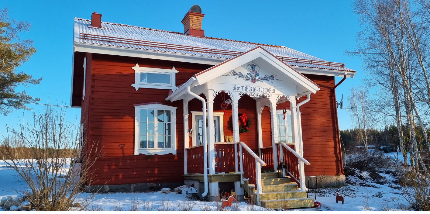 Red swedish house in snow with house decoration