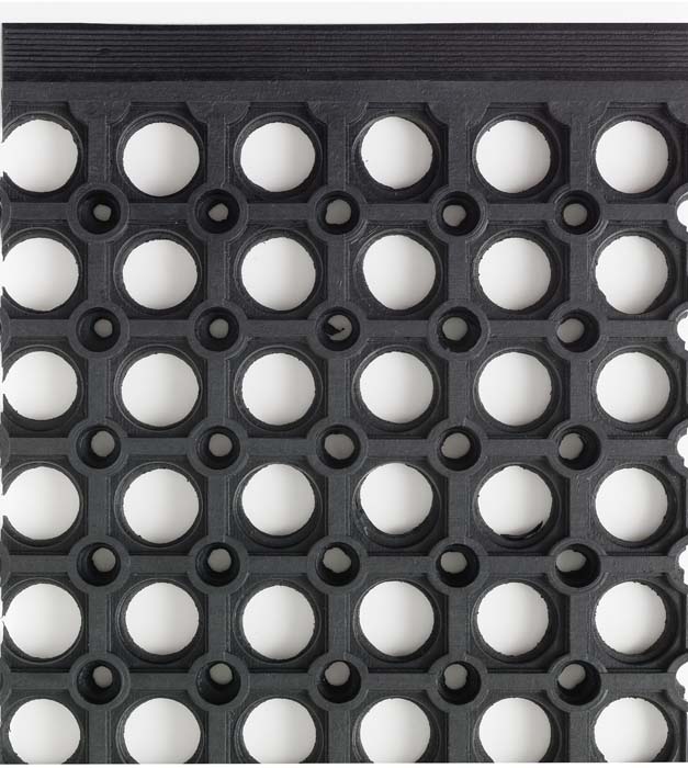 Närbild på svart skrapmatta i gummi med runda hål