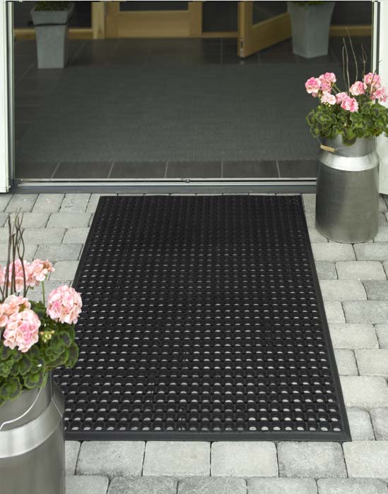 Svart skrapmatta med runda hål utan en dörr