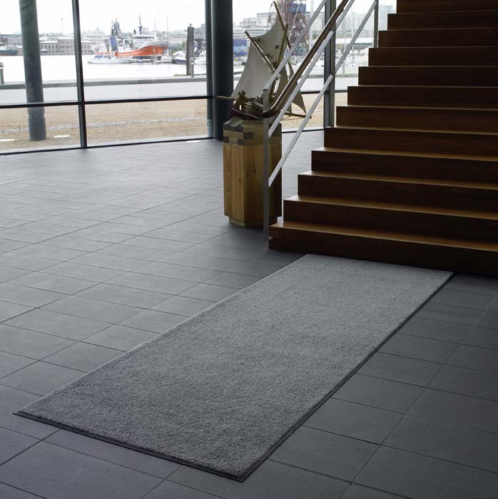 Torkmatta grå på golvet nedanför en trappa