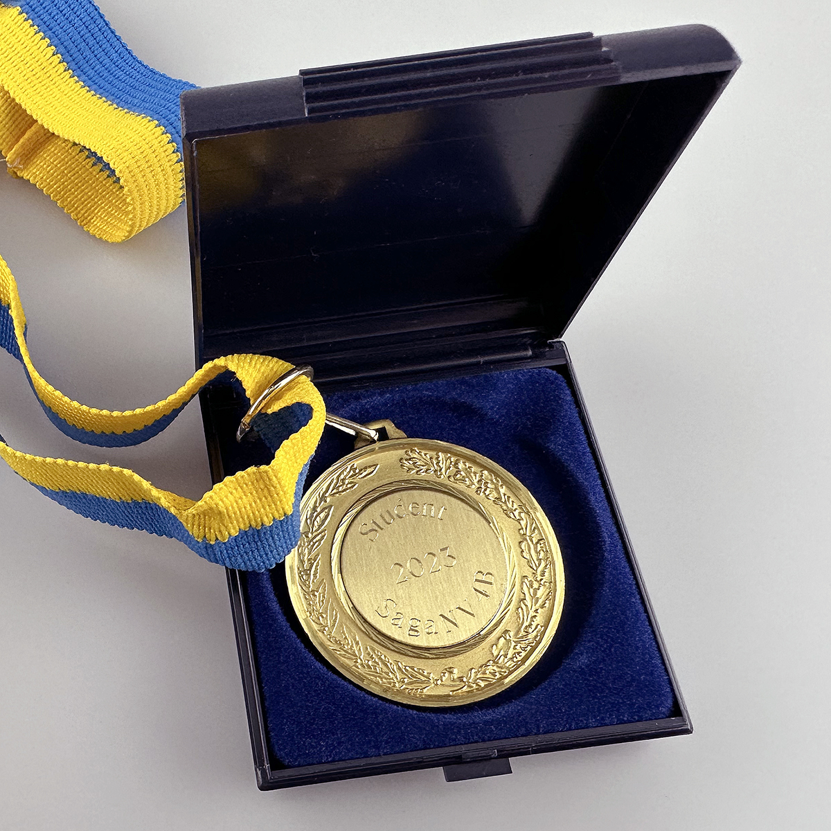 Medalj med Sverigeband i förpackning gravyr ingår