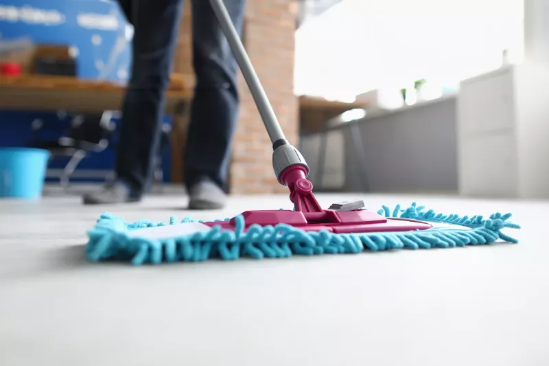 Närbild på hand som torkar yta med mikrofiberduk under rengöring