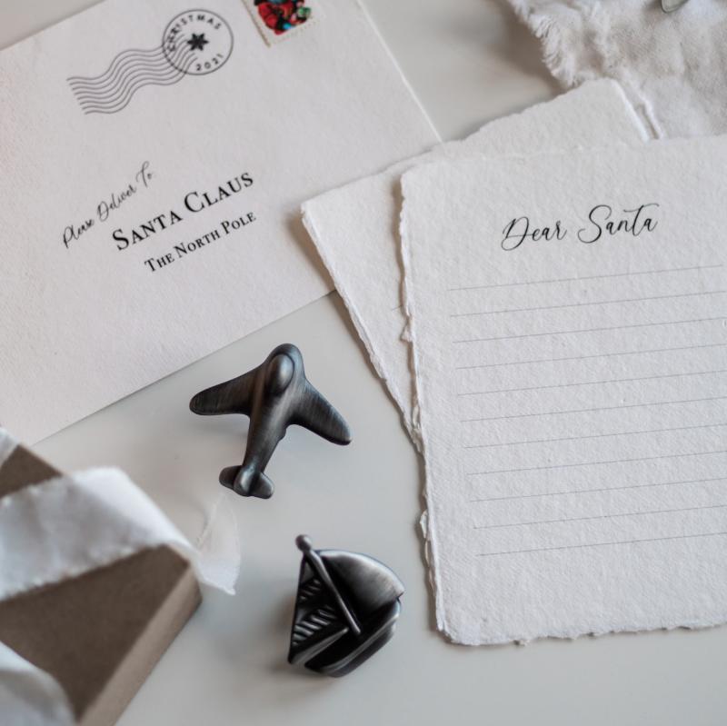 Önskelista till tomten med byråknoppar i form av flygplan och båt.