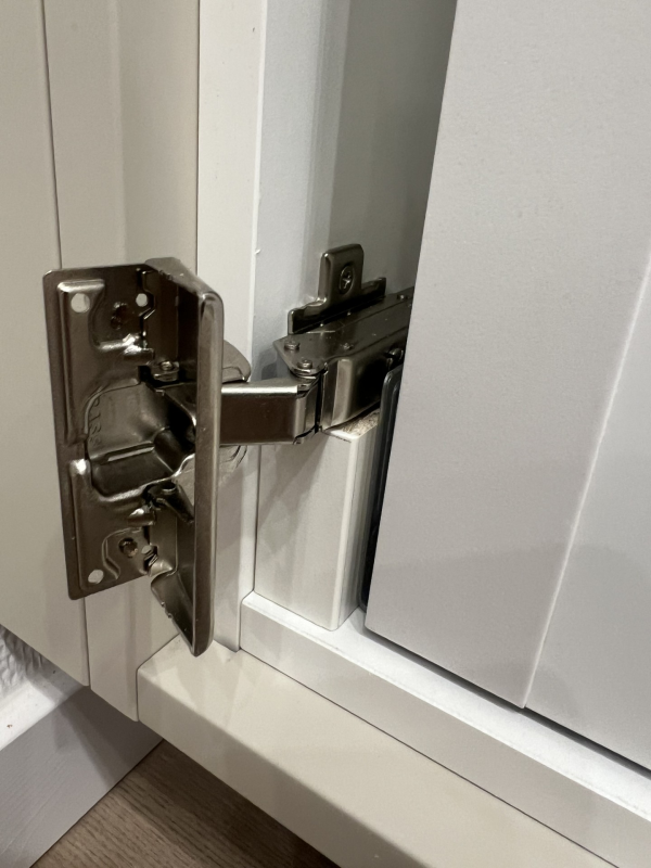 Distanser monterade bakom lådskena för att undvika kollision med gångjärn.