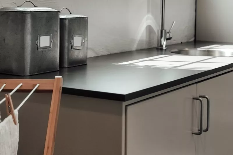 Two dark pull handles on light kitchen doors