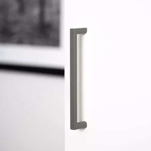 Grönt möbelhandtag från Linfalk, 128 mm, monterat på en garderobsdörr.
