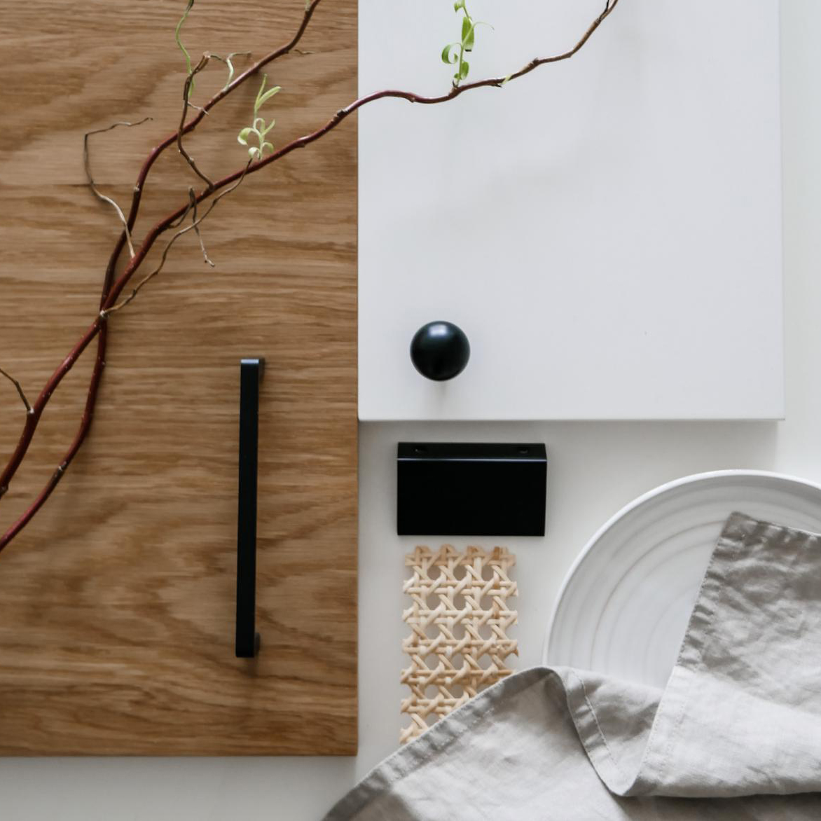 En stilren japansk-inspirerad kökslayout med rotting och svarta kökshandtag..