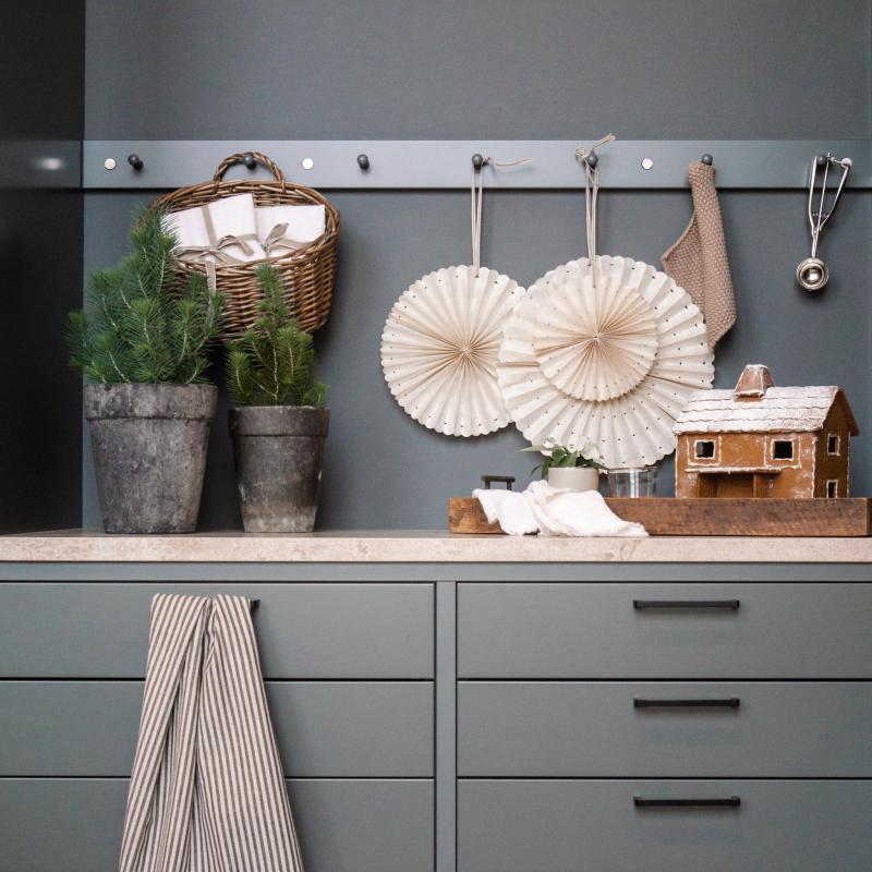 Mörkgrått julpyntat kök med svarta handtag och lackerad kroklist.