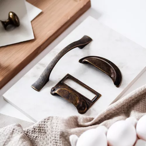 Skålhandtag, etikettgrepp och bygelhandtag i antik mässing – vintage stil till köksskåp