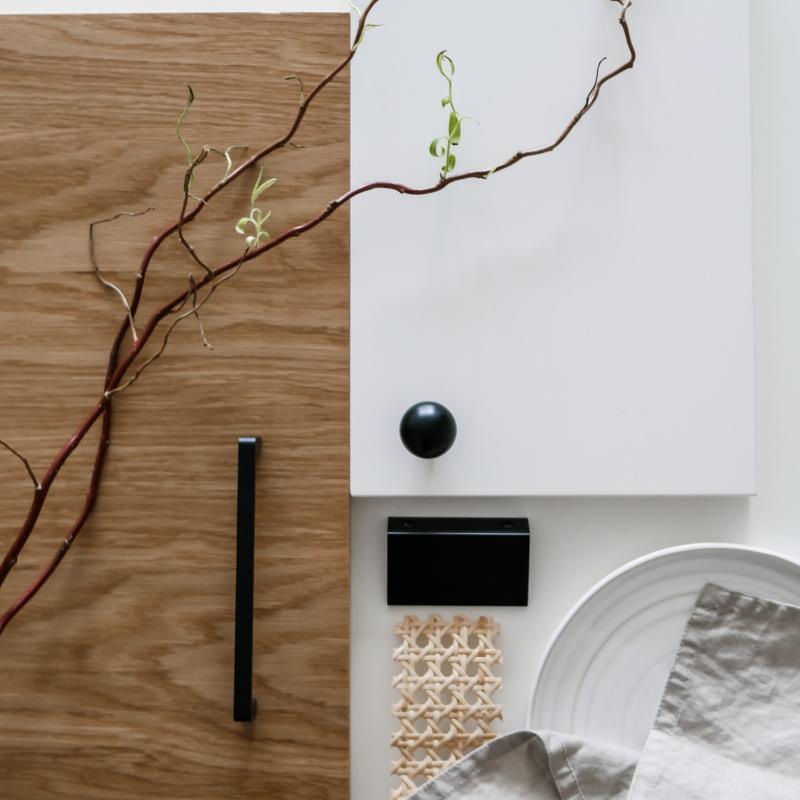 Stilleben med inspiration till köksrenovering i japandistil innehållande trälucka, rotting och svarta köksbeslag.