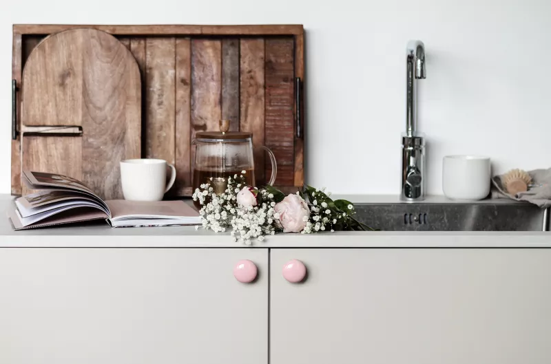 Runda rosa köksknoppar på vit lucka med blommor