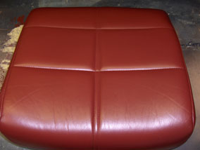 bild på omfärgad röd soffdyna i läder
