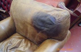 bild på fettfläck på brun läderfåtölj före behandling med avfettningsmedel från varumärket furniture clinic