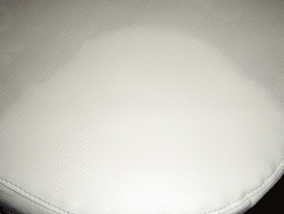 närbild på krämfärgad soffdyna i läder som är delvis rengjord med läderrengöringsmedel