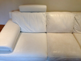 bild på krämvit skinnsoffa som visar effekten av rengöring med ultra clean läderrengöring. Halva soffan är rengjort, och andra halvan är smutsig