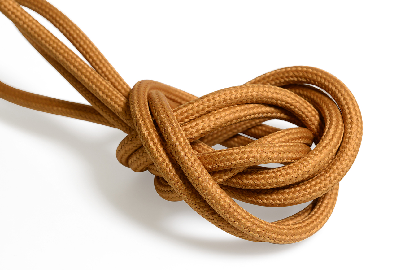 Mörk orange textilkabel. Kabeln är jordad och finns i flera olika längder.