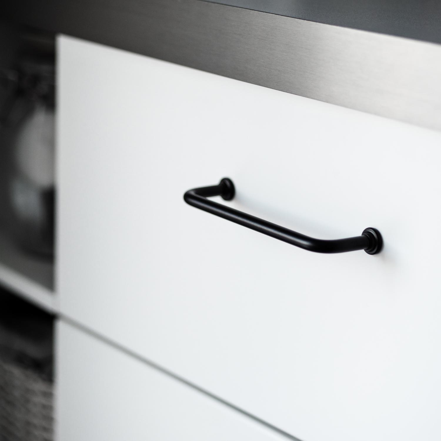 Handtag 1353 i svart mot vit lucka och grå bänkskiva.