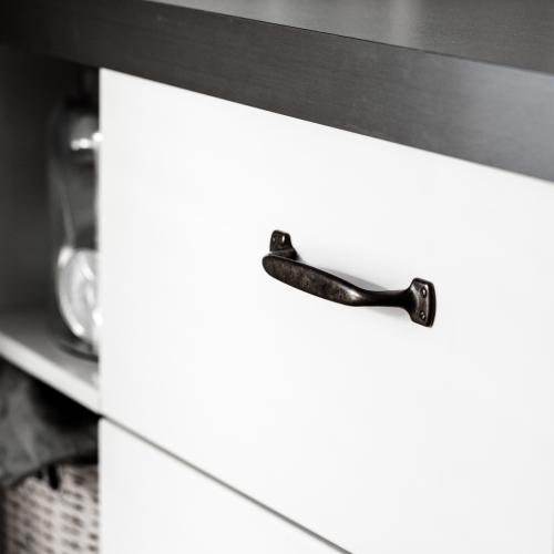 Lantligt kökshandtag i antik mot en vit kökslucka och grå bänkskiva