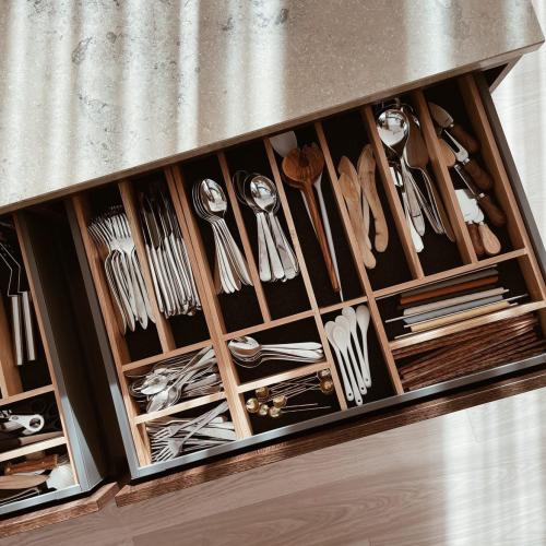 Besticklåda i ek i en mörkgrå kökslåda mot ljust trägolv och beige bänkskiva