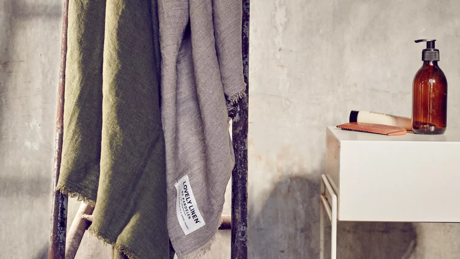 Linnetextilier: ett naturligt och elegant material med djupa rötter En närbild av en prydligt hängande baddukar linne på ett ställ bredvid ett vitt träbord.