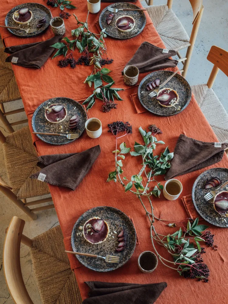 Dukat bord med linneduk i Lovely Cayenne, mörkbruna linneservetter och höstliga detaljer.