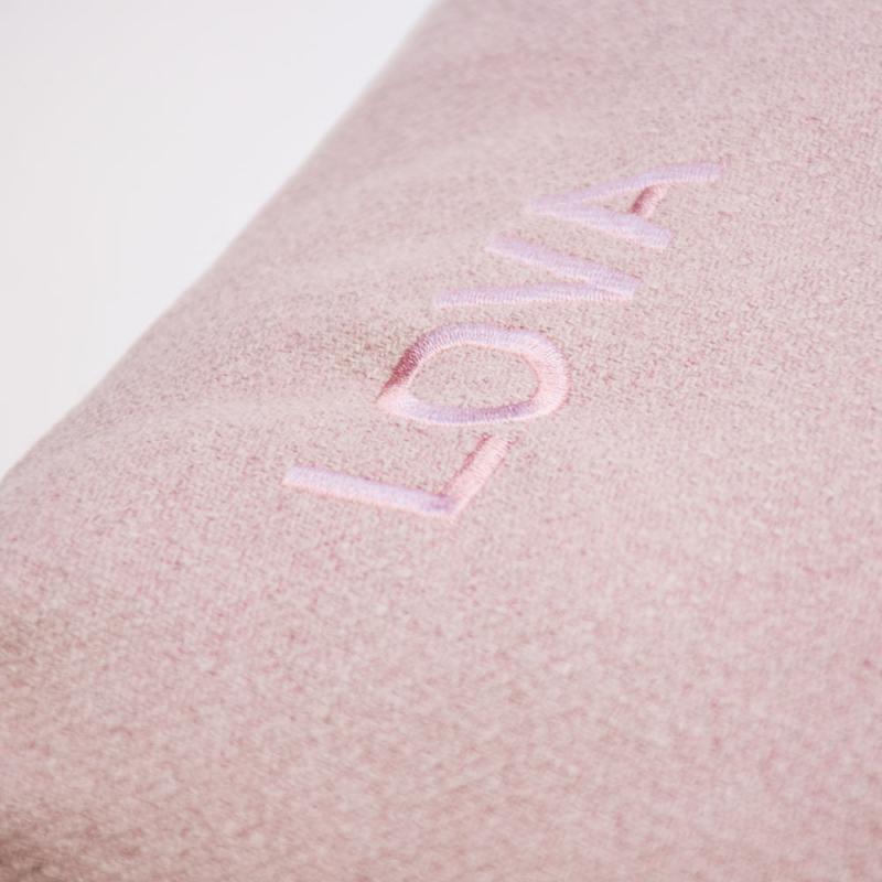 Närbild på namnet Lova graverat på rosa bäddkudde för hund eller katt.